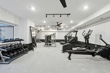 A spacious gym with a variety of equipment including treadmills, weights, and exercise machines.